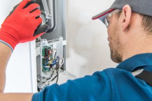 man works on furnace