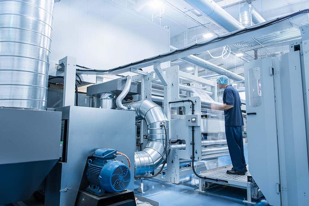 Worker operating printing machine in food packaging printing factory