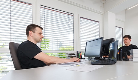 Two men working on desktop computers