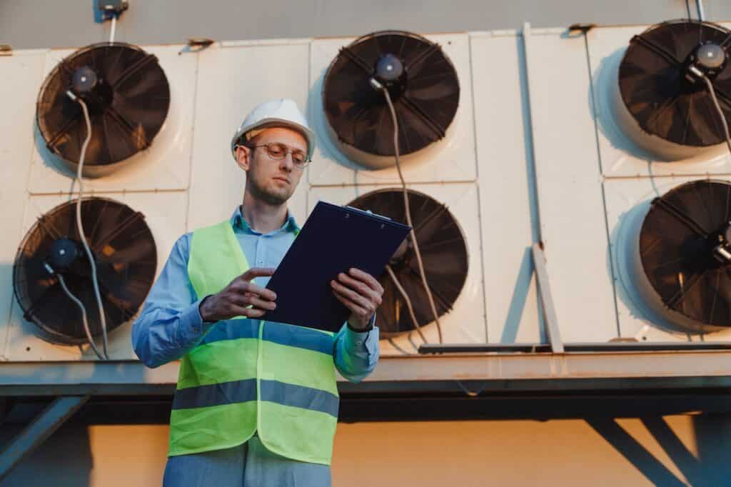 Engineer inspecting chiller redundancy systems at industrial firm